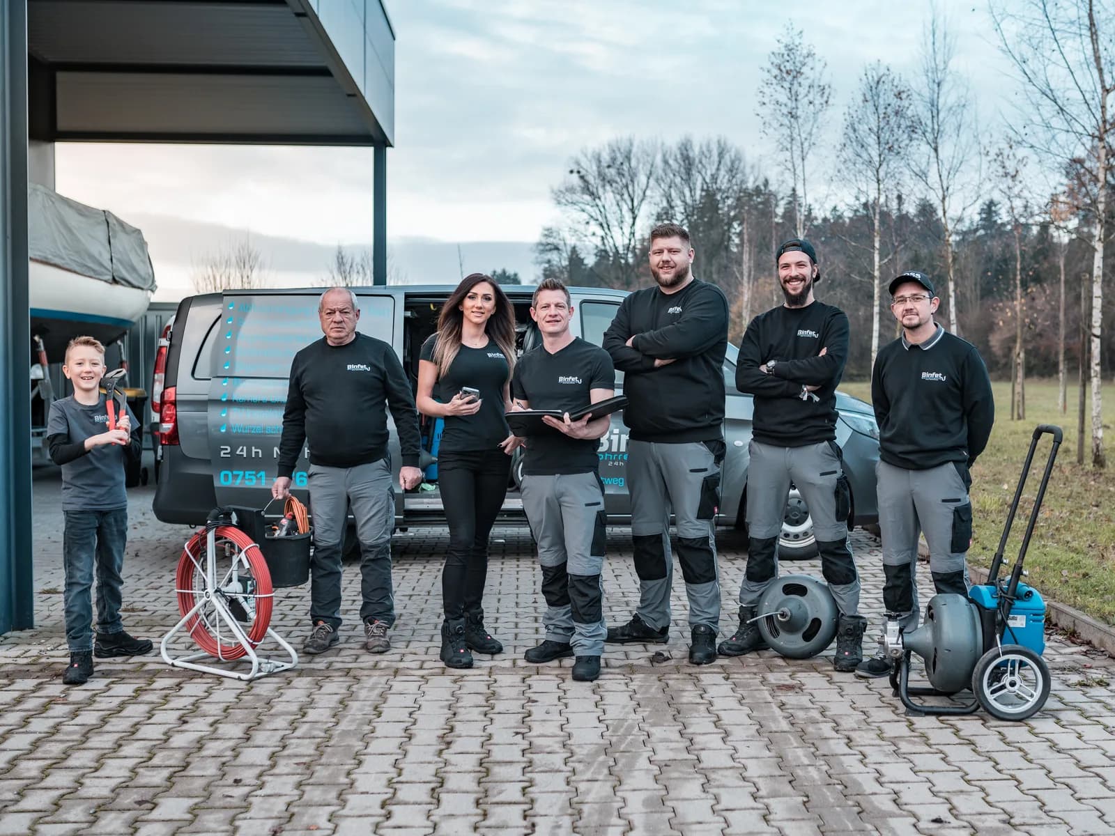 Das komplette Team der Binfet Rohrreinigung vor den Einsatzfahrzeugen