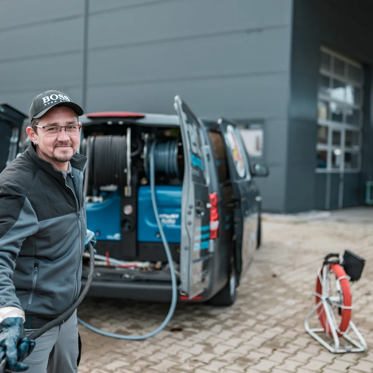 Techniker bedient Saugwagen beim Entleeren einer Abwasser-Anlage